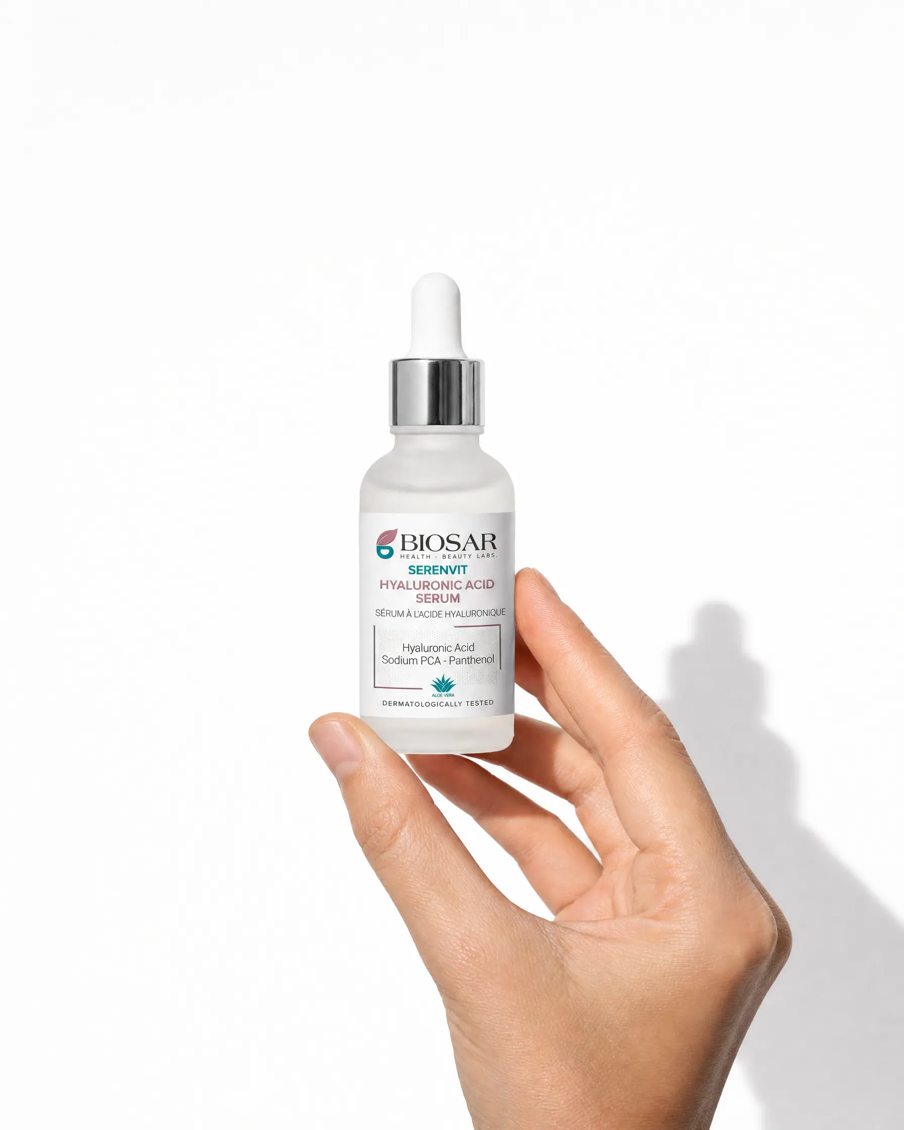 Hand holding the BIOSAR Serenvit Hyaluronic Acid Serum 30 ml dropper bottle on white